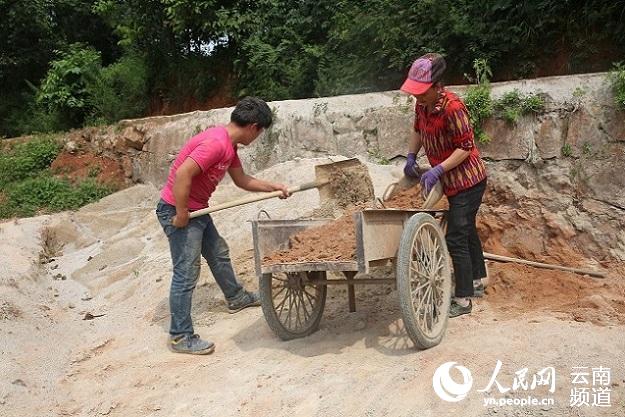 崔庆涛和母亲在装沙土 陈耀邦摄