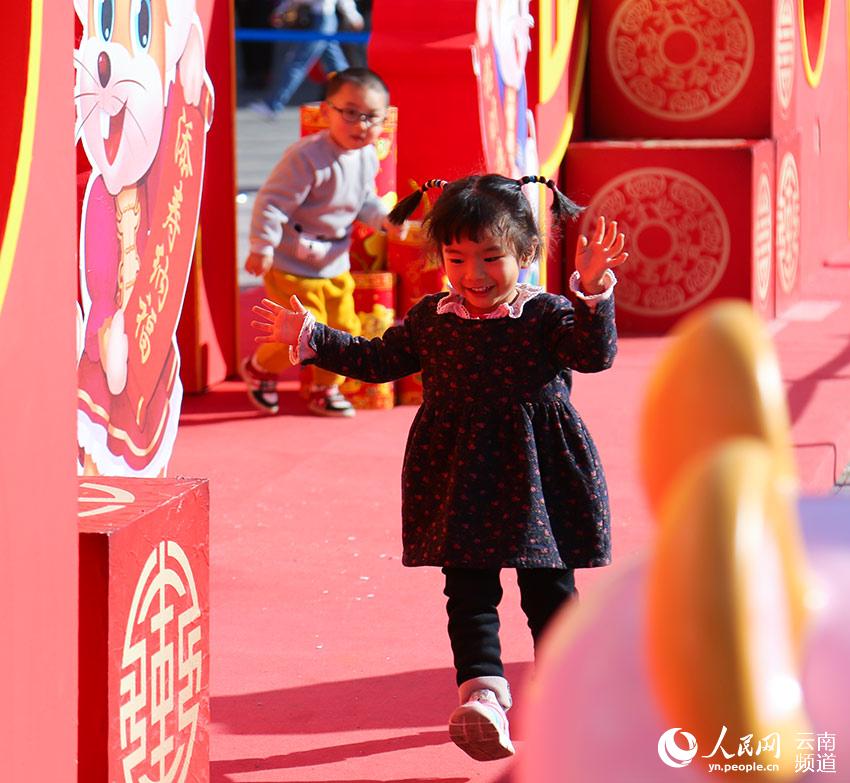 兩個小孩在昆明新春購物博覽會現場嬉戲。（人民網 李發興 攝）
