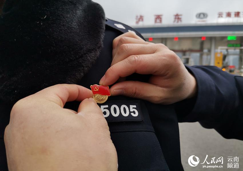 擦拭黨徽，讓它在防疫一線熠熠生輝。供圖
