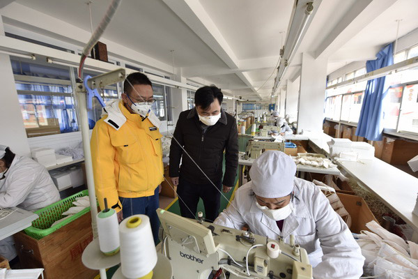 工人在一絲不苟加工口罩（供圖）