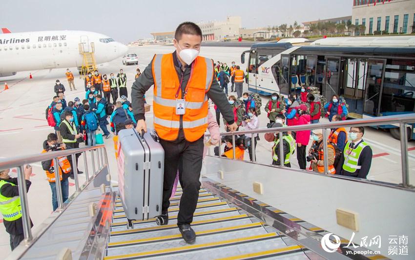機場工作人員為醫護人員提行李。（人民網 虎遵會 攝）