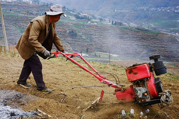村民胡昌慶正用微耕機耕地，准備在地裡栽種烤煙。