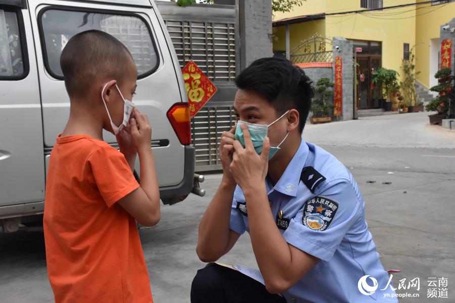 5月30日，瑞麗邊檢站民警到駐地所在的賀悶村寨，為傣族兒童送去兒童口罩，並教他們正確佩戴。（何星余攝）
