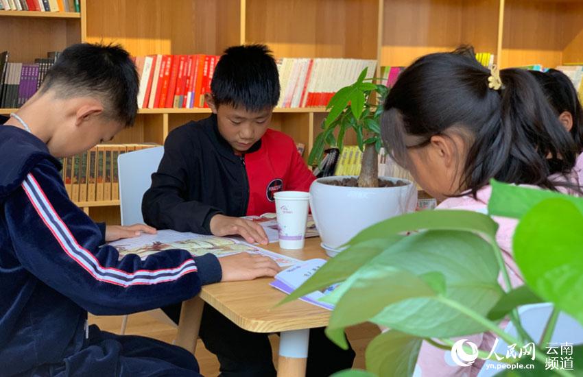 在會澤縣新時代文明實踐中心裡易地搬遷的孩子們正在閱讀書籍（人民網 曾智慧 攝）