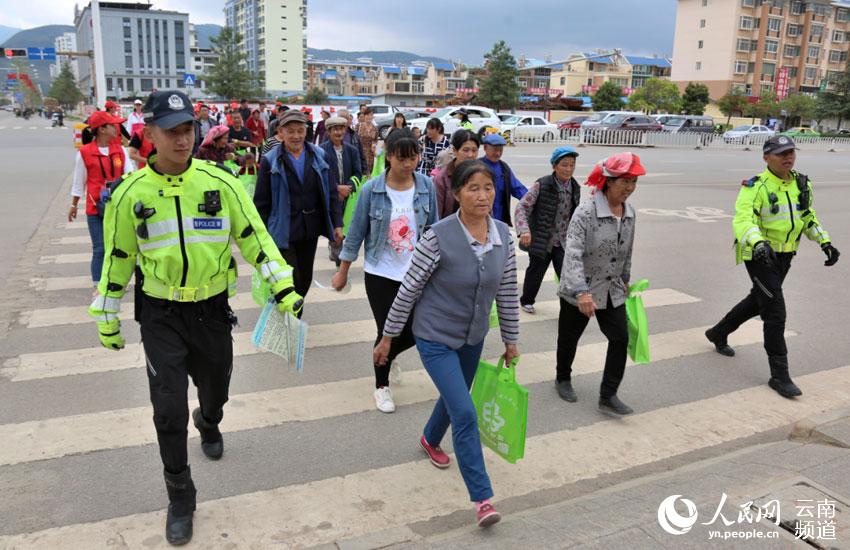 會澤縣新時代文明實踐中心的志願者正在教群眾如何過馬路（供圖）