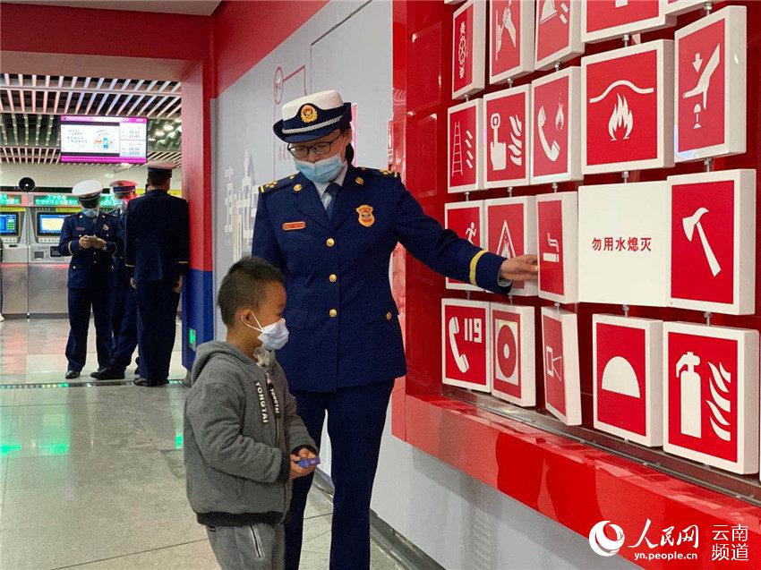 昆明五華區消防大隊工作人員正在向5歲的朱梓睿普及消防知識（人民網 曾智慧 攝）