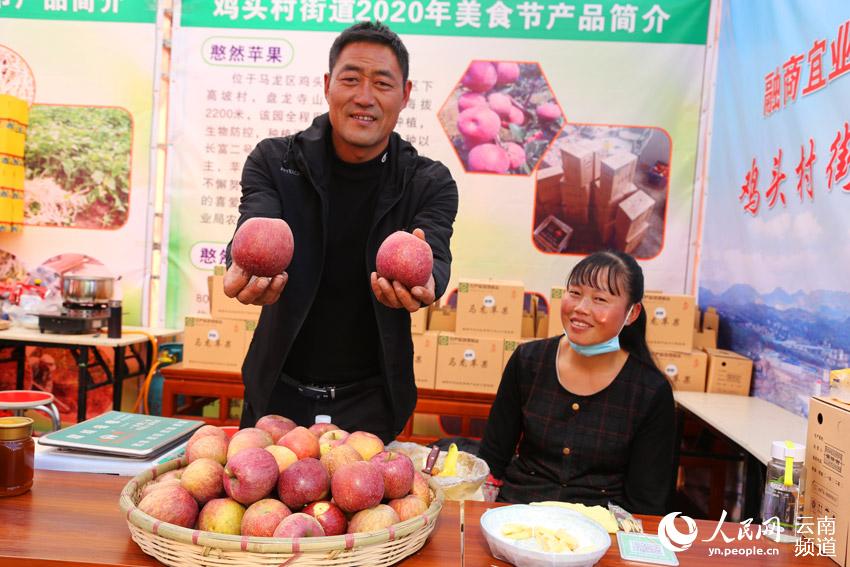 董德青在推介自己種植的馬龍蘋果。（人民網 符皓 攝）