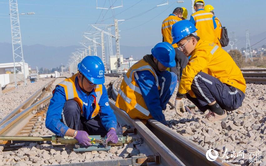11月26日，幾名施工人員正在對鐵軌進行調試。（人民網 虎遵會 攝）