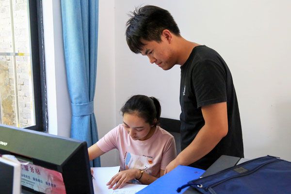 夫妻兩人在認真核對工作台賬。肖寬供圖