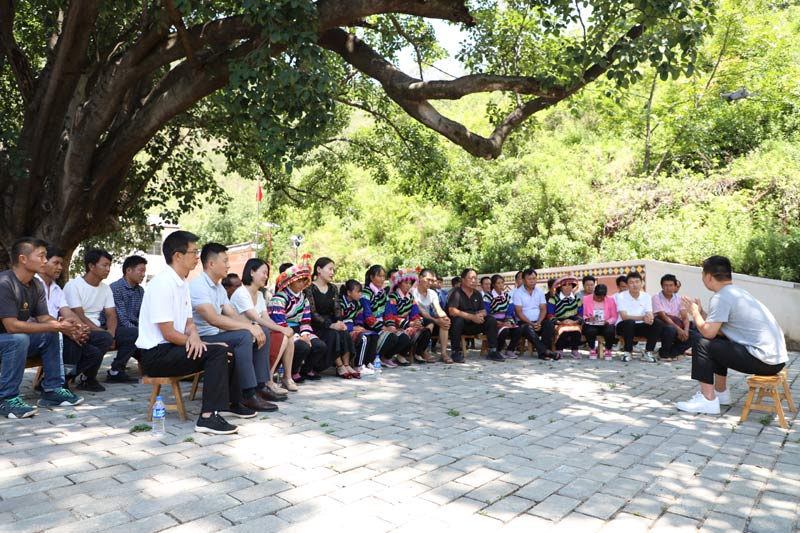 在钟英乡唐古地村，村民们和宣讲团成员围坐在一起，认真听着党史故事。