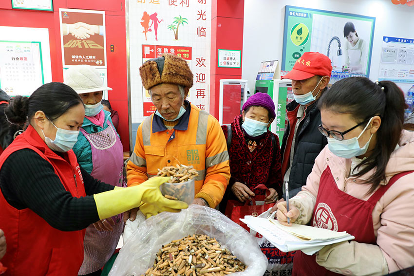 超市员工为市民捡拾的烟头进行回收兑换商品。