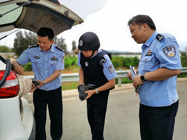 嵩明县副县长、县公安局党委书记、局长杨绍聪（左一）检查接处警装备。