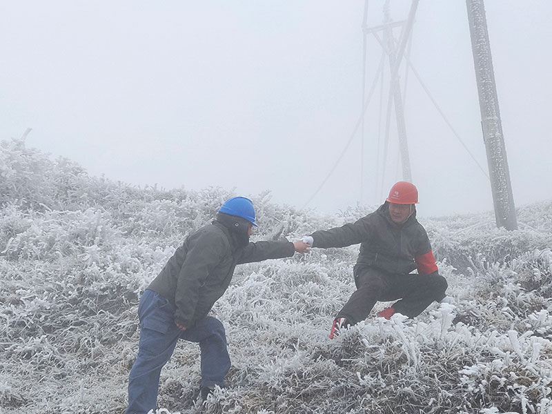 曲靖宣威供電局在線路特巡途中互相攙扶。龔航攝