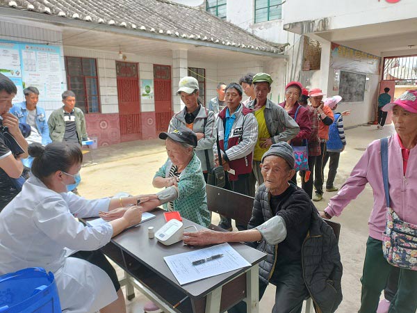 疫苗接种前，医务人员为老人们测量血压。景东县融媒体中心供图