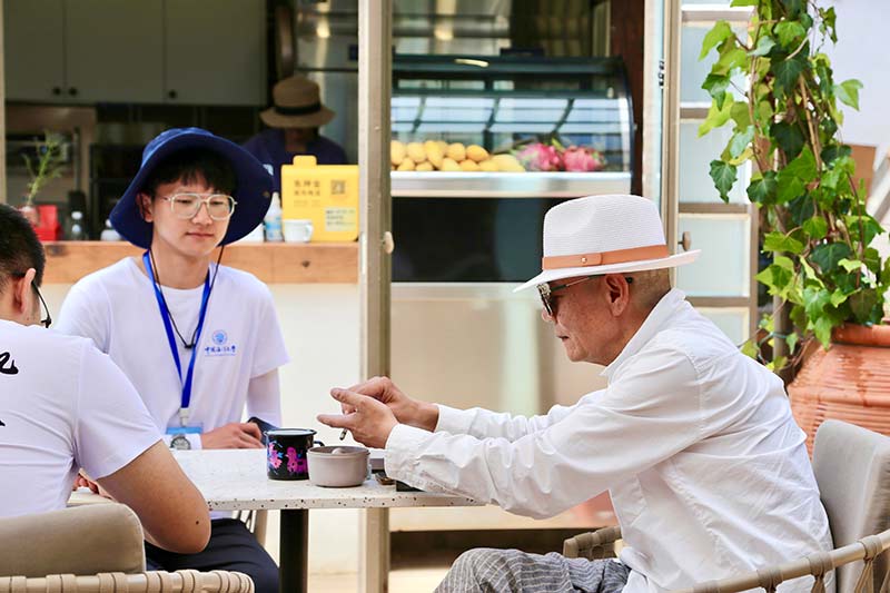 農民畫社“雞窩”咖啡館內-沈見華老師正在和調研團成員交流。畢家琪攝
