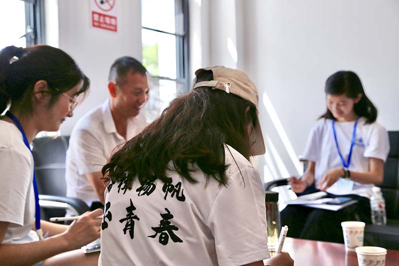 中國海洋大學“蒼洱大地上的鄉村藝術”實踐隊成員與伙山村黨支部書記張軍交流。畢家琪攝