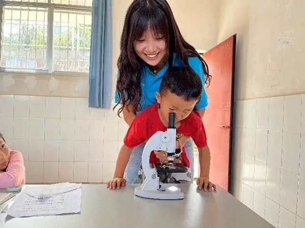 小朋友用显微镜观察岩石矿片。南华县融媒体中心供图