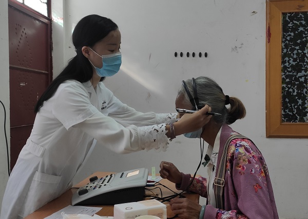 工作人员正为群众调试助听器。景东县融媒体中心供图