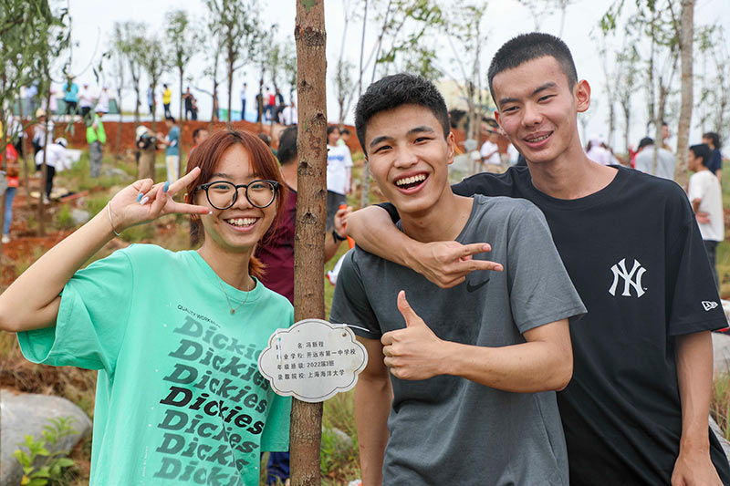 即將奔赴高校開啟人生新旅程的學子們與自己親手種下的樹苗合影。陶家淇攝
