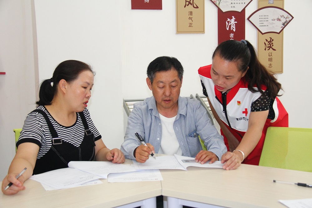 吴泰来的父母正在“中国人体器官捐献志愿登记表”上签字。蒙自市融媒体中心供图