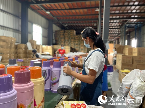 瑞丽市美诺塑胶有限公司的包装车间，缅籍工人正对刚生产的保温壶进行包装。人民网记者 程浩摄