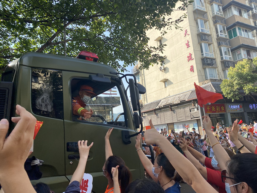 重慶市民豎著大拇指歡送滅火英雄。楊歡攝