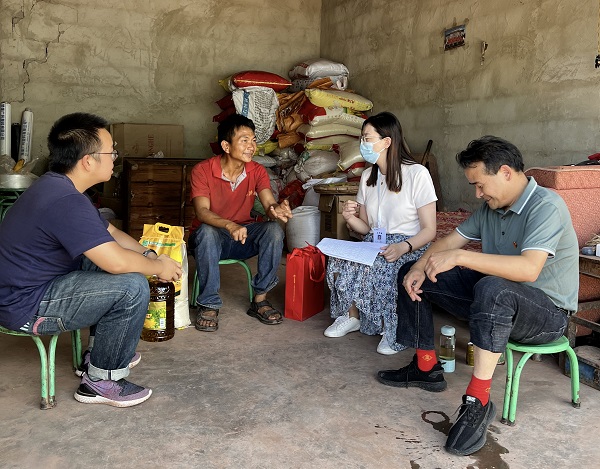 在政府提供的安置房里，工作人员与方师海（左二）交谈。李耀辉摄