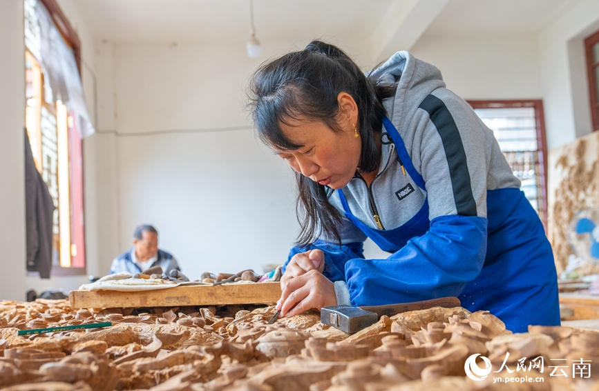 一名木雕師正在雕刻作品。人民網 虎遵會攝