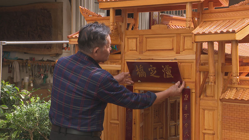 普明才為他的木雕作品《飛奪瀘定橋》裝上最后一件輔件。郭雨晨攝