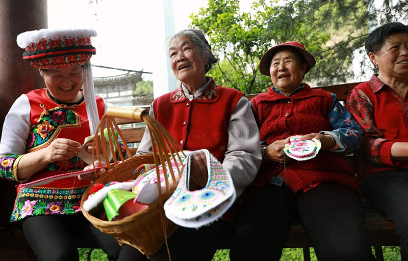 五華區婦女群眾們圍坐在一起做刺繡。