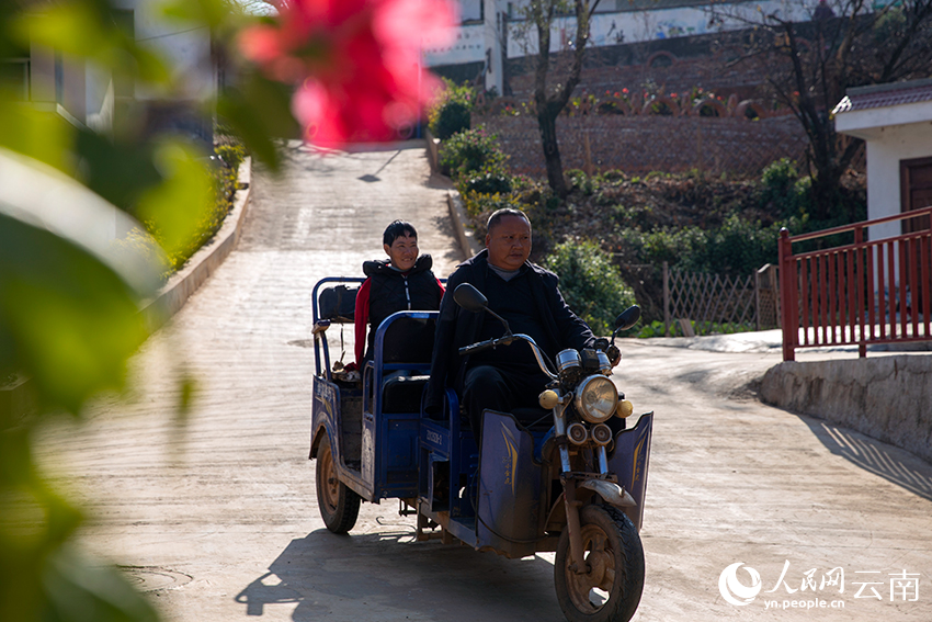 村里环境好了，张顺东常骑车带着妻子在村里转悠。人民网记者 程浩摄
