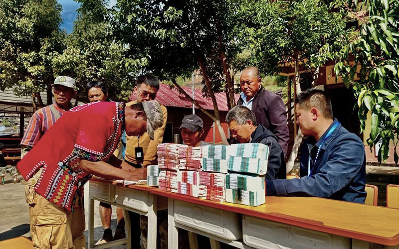 收购企业分发豆款给村民。马晓东摄