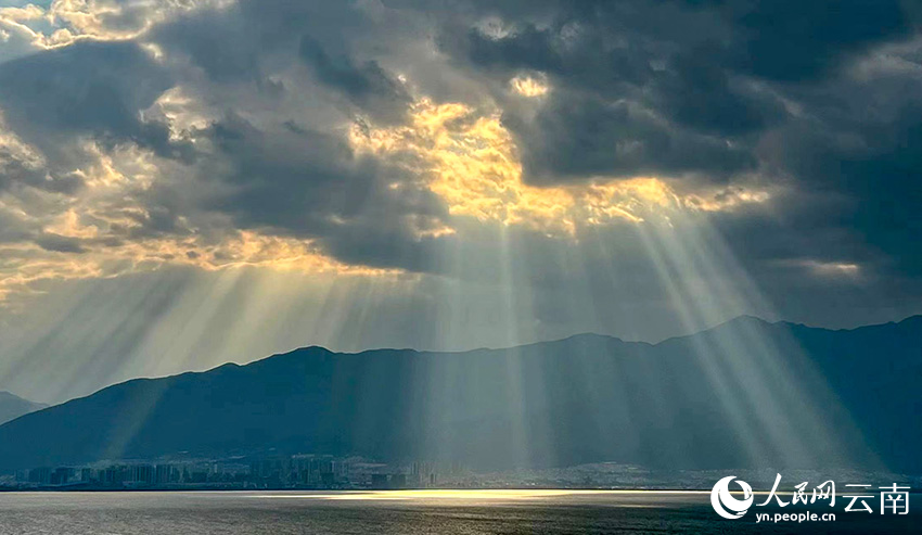 2月20日下午，一束束金光穿透雲層照向山岳湖面，萬丈光芒與蒼山洱海交相輝映。楊岳雷攝
