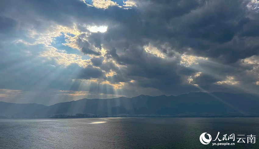2月20日下午，一束束金光穿透雲層照向山岳湖面，萬丈光芒與蒼山洱海交相輝映。楊岳雷攝