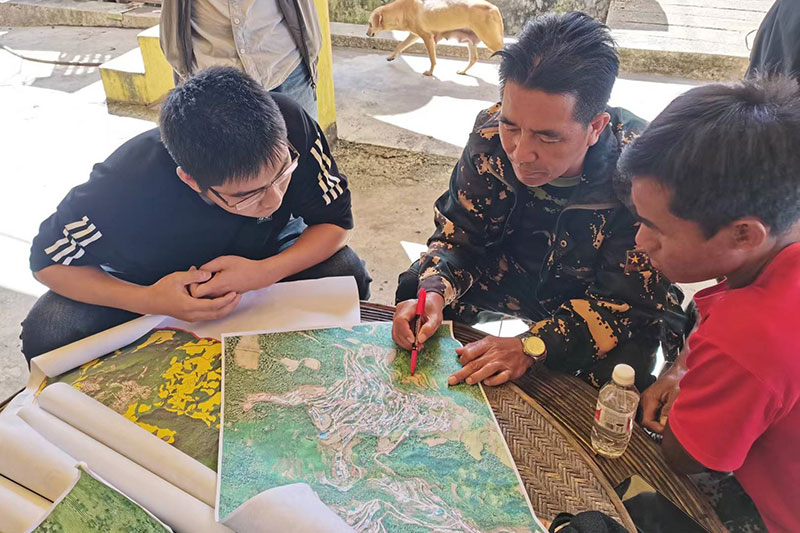 永不落村干部在研究地图。艾嘎摄