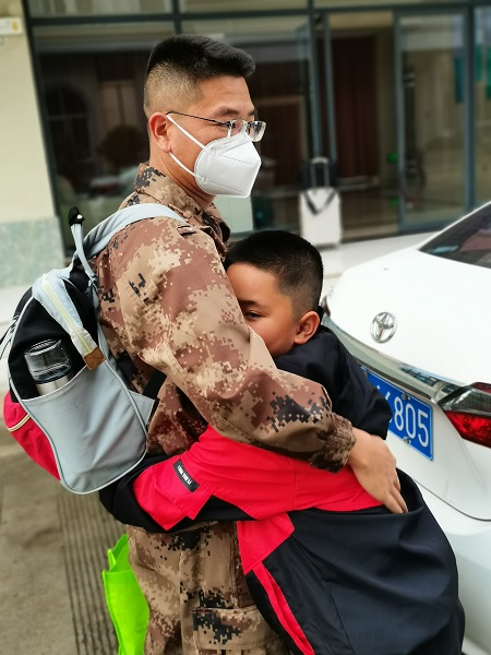 一次出差归来，程波和儿子抱在一起。供图