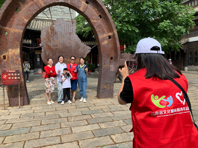 文化和旅游志愿者帮游客拍照