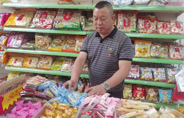 周才发在整理店内百货陈列。
