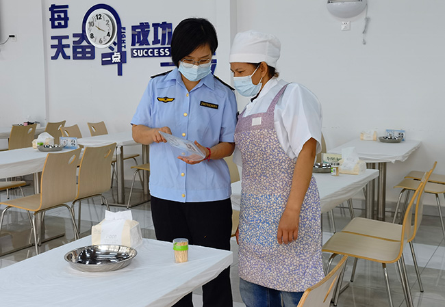 市场监管工作人员查看节约宣传标语