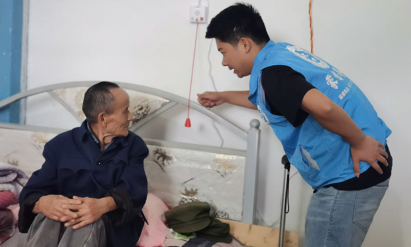工作人员向老人讲解活动探测对讲器的使用方法及功能。张艳娥摄