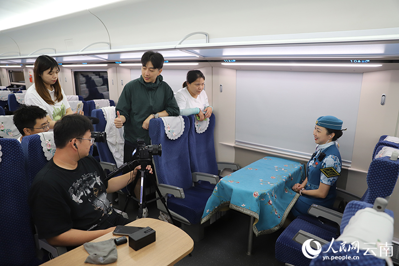 采访团在中老铁路国际旅客列车上采访列车长。人民网记者 李发兴摄