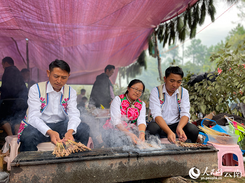 罗鸿（左）和其他人一道烤羊肉串。人民网记者 程浩摄