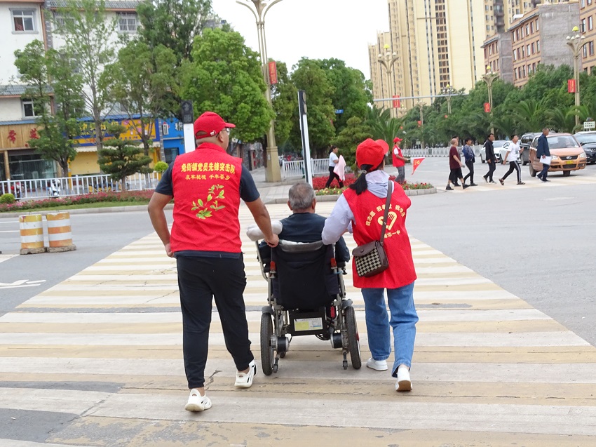 帮助老人过斑马线。者美春摄