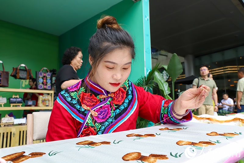 7月29日，南華縣在昆明舉行推介活動，繡娘將野生菌繡在布上。人民網記者 虎遵會攝