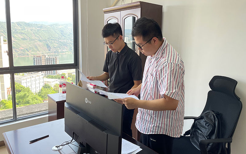 上海市闵行区闵资集团团委书记钱诚（右一）在绥江县开发投资有限公司整理档案资料。
