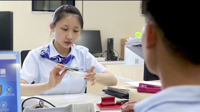 建行云南省分行工作人员正在为客户办理“关银一Key通”业务。