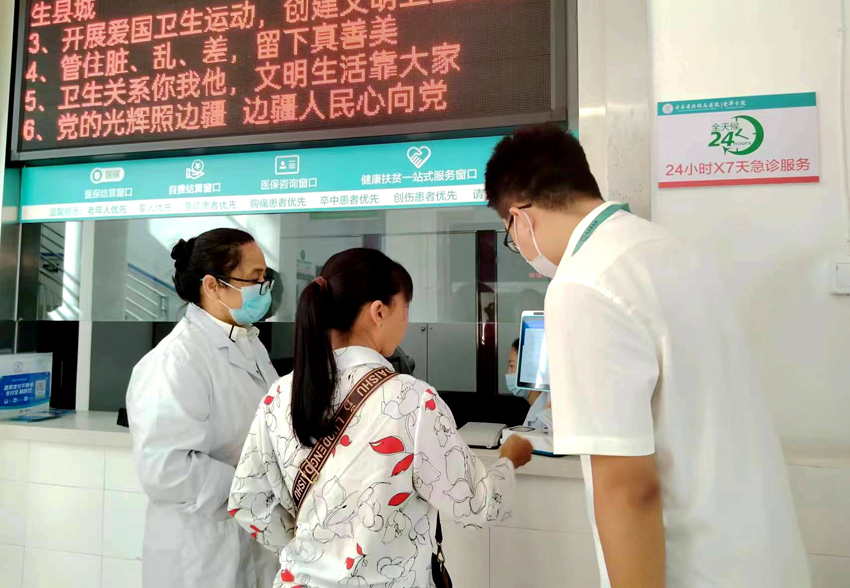 云县爱华镇卫生院工作人员指导患者使用刷脸结算。云县融媒体中心供图