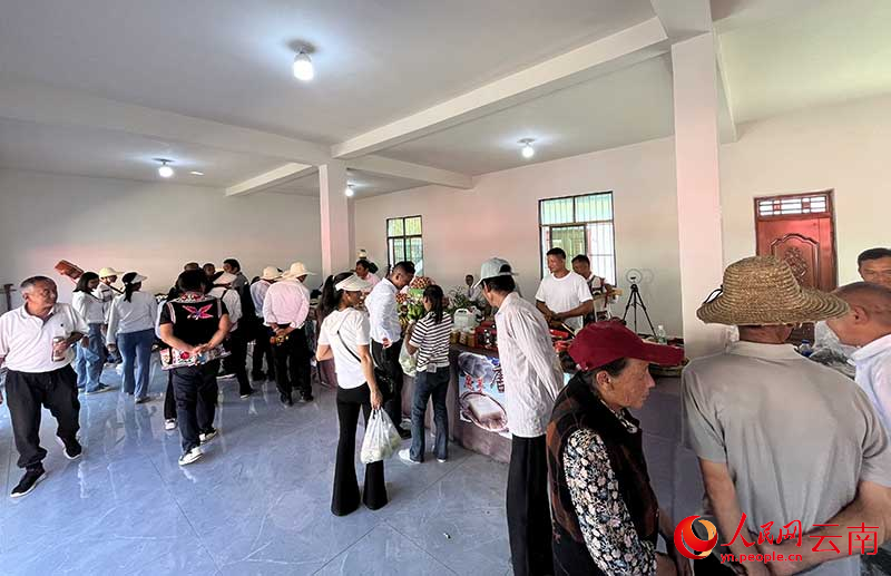 村民们参观各村委会展销的农特产品。人民网 尹馨摄
