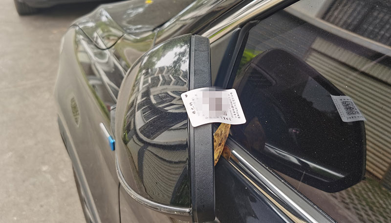貼在汽車駕駛位后視鏡的二維碼。蘇紅亮攝