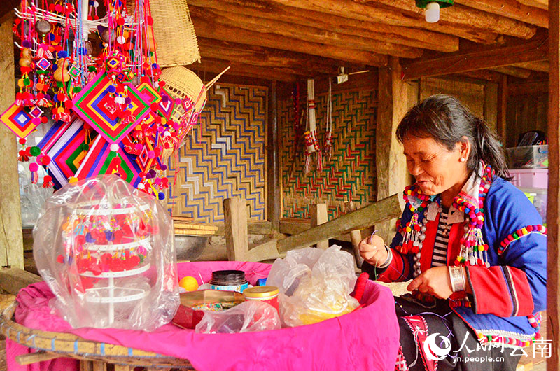 【2】传统木楼中，一位德昂族妇女制作着极具特色的德昂织锦。人民网记者 刘怡摄